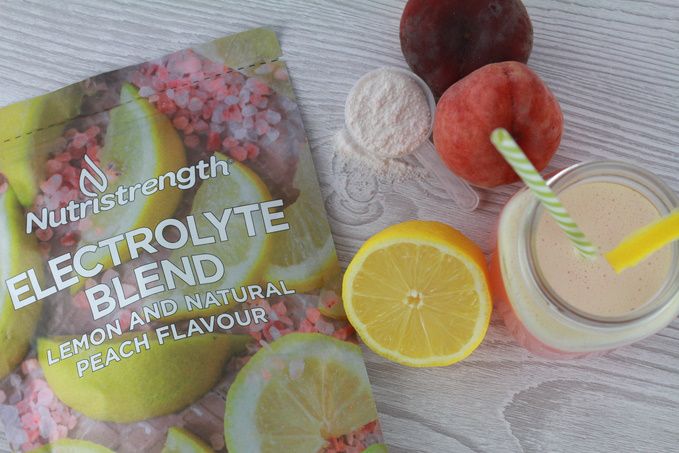 electrolyte blend on wood background with drink and lemons and peaches