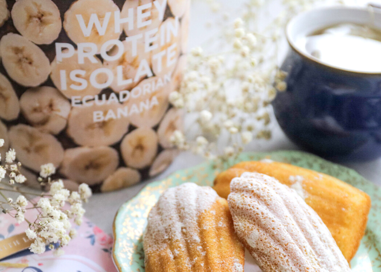 Nutristrength Protein powder container with cookies and a cup of coffee on a table
